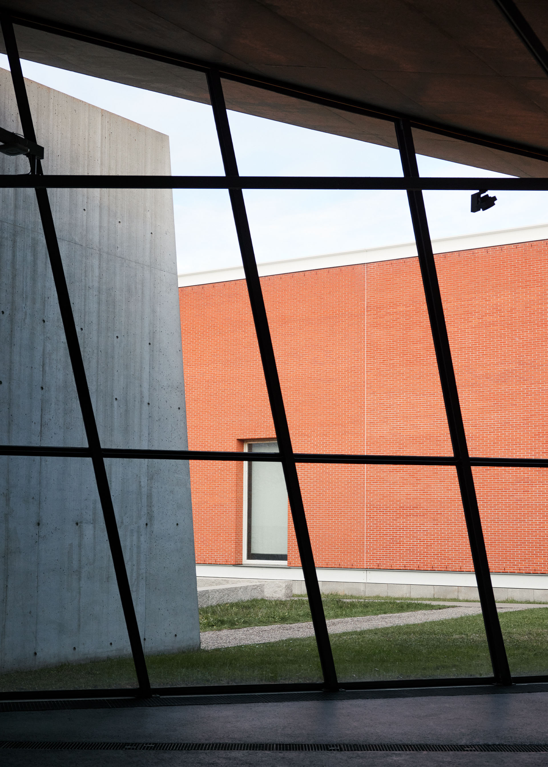 View through a glass facade to a brick building.